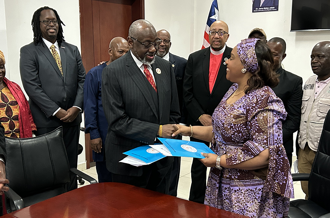 Dr. Mark Brown exchanges MOU documents with Minister of Education Dr. Jallah