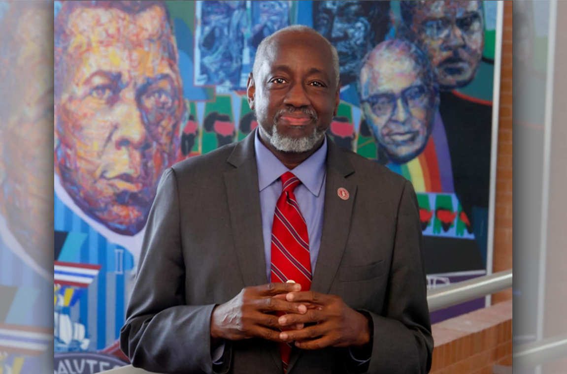 Picture of Dr. Mark Brown standing in front of a mural in Kresge Center on campus