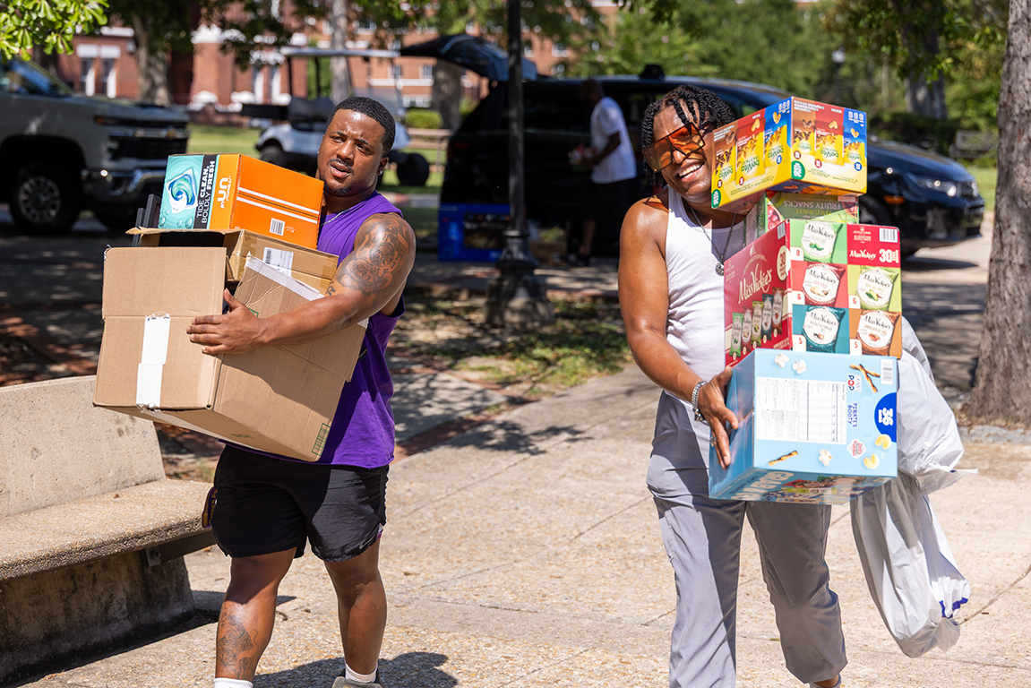 Two students carrying boxes