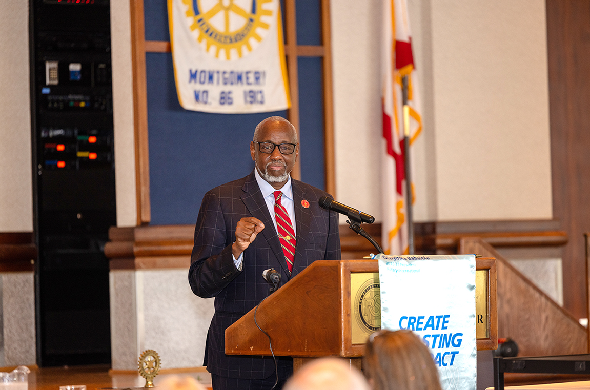 Dr. Mark A. Brown at podium speaking to the Rotary Club audience