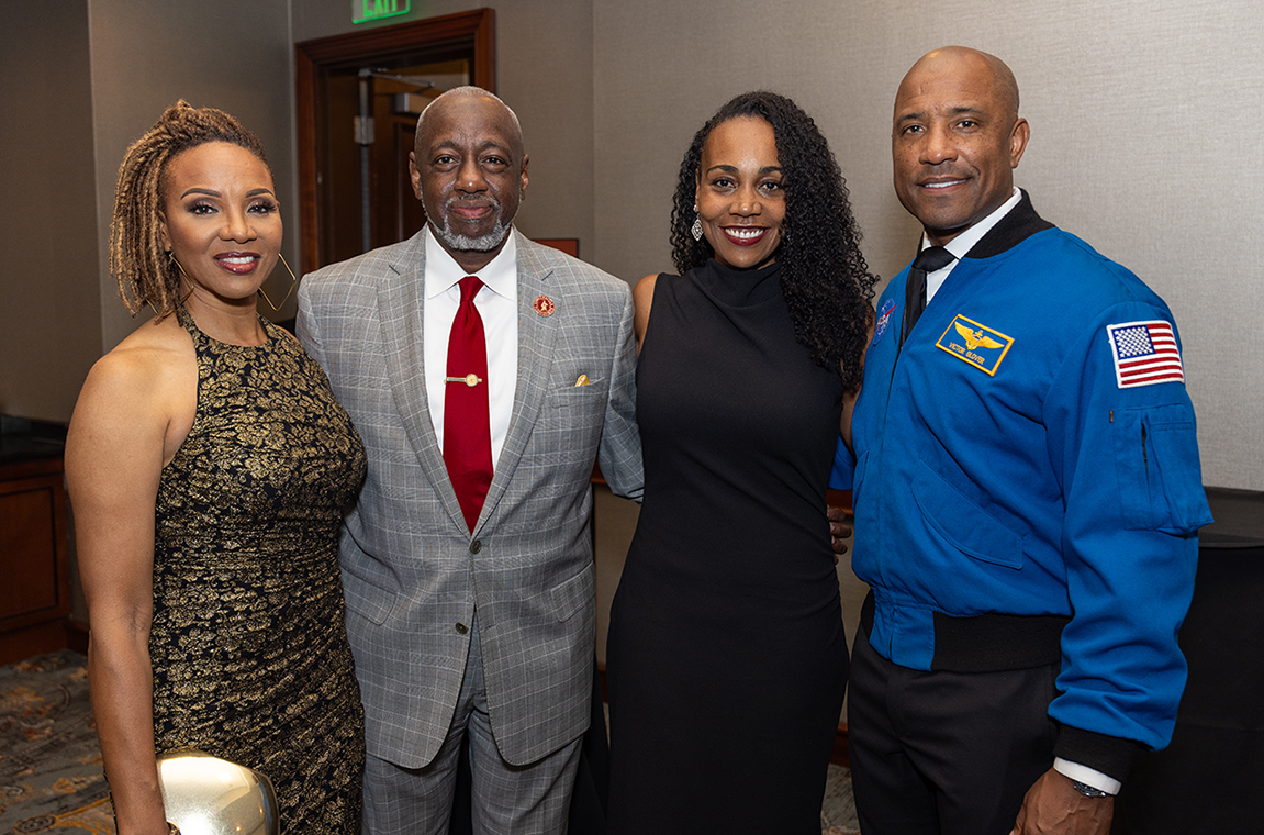 MC Lyte and Dr. Mark A. Brown standing with NASA astronaut Capt. Victor Glover and his wife
