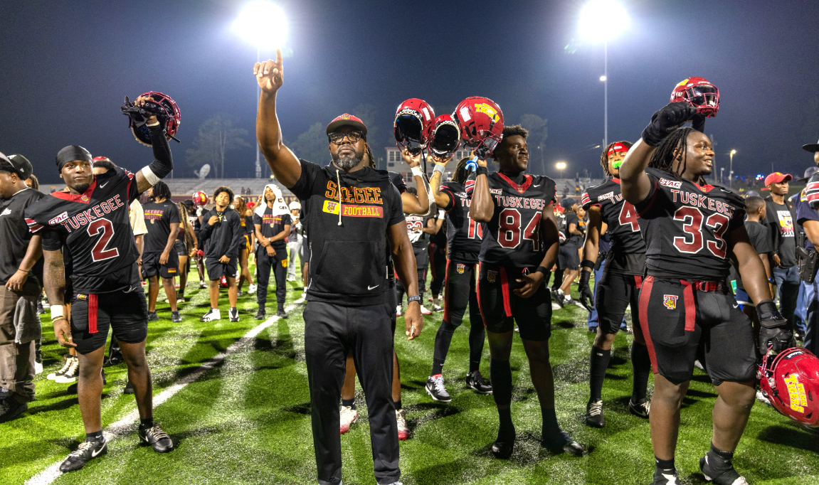 Picture of football team celebrating on the field after the win.